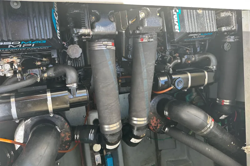 Slide: The Image of Engine compartment of a 1999 Sea Ray 310 Sundancer boat, showcasing dual engines and components. - 25