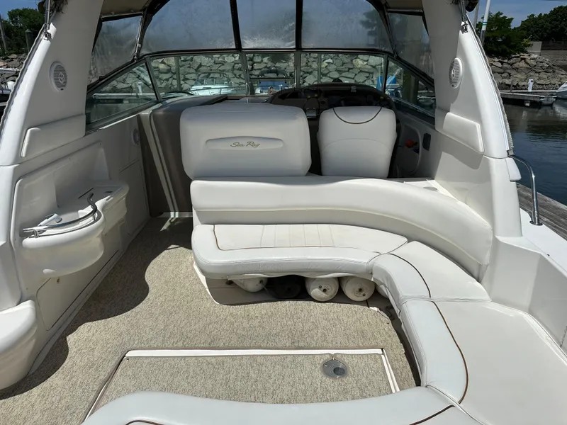Slide: The Image of 1999 Sea Ray 310 Sundancer boat interior with white seating and helm. - 9
