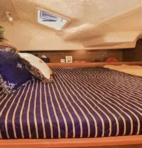 Slide: The Image of Interior cabin of a 2009 Hunter 36 sailboat with a striped bedspread. - 9