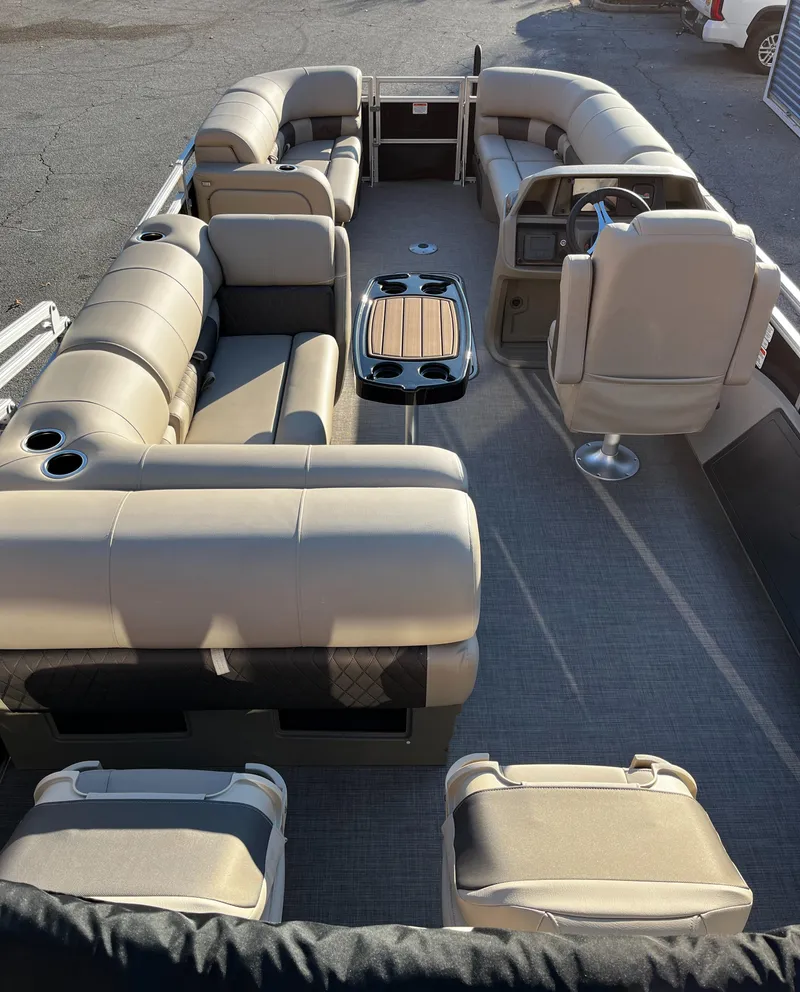 Slide: The Image of 2024 Sun Tracker Sportfish 24 XP3 pontoon boat interior with beige seating and steering console. - 3