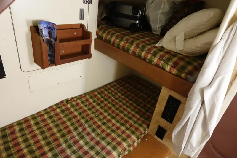 Slide: The Image of 1988 Donzi Z-65 Tournament Fisherman cabin with plaid bunk beds and storage shelves. - 45