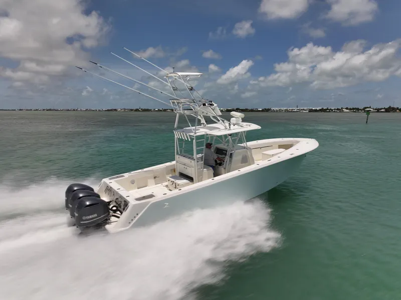 Slide: The Image of 2015 SeaVee 370z boat speeding on water with triple outboard engines. - 12