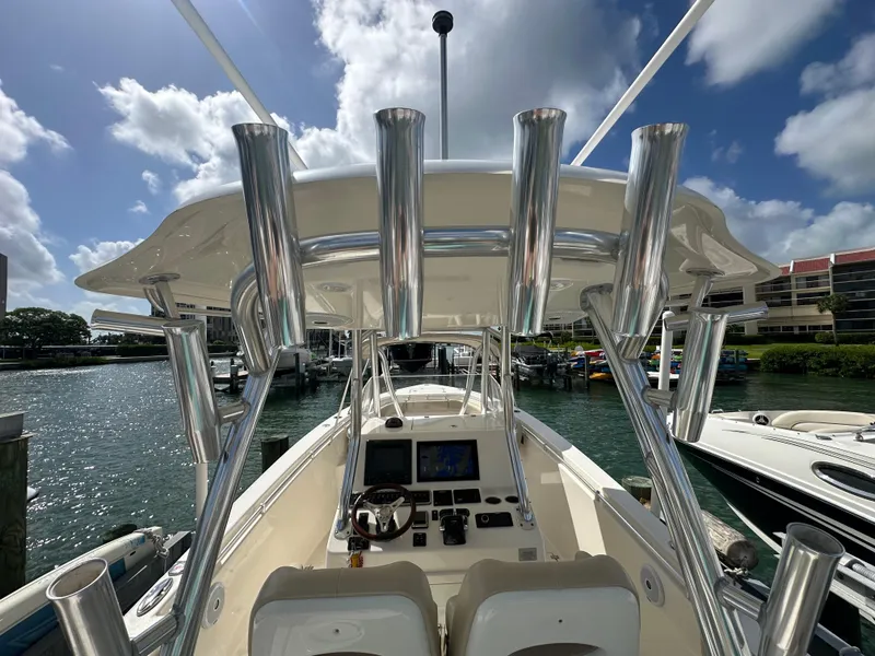 Slide: The Image of 2016 Cobia 296CC boat at marina, view of helm and rod holders. - 12