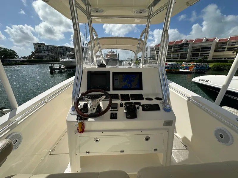Slide: The Image of 2016 Cobia 296CC boat helm with navigation screens and controls. - 13