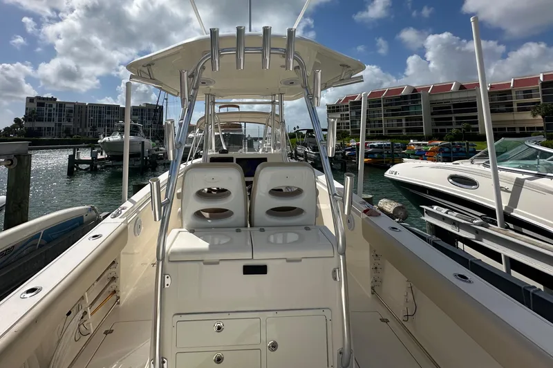 Slide: The Image of 2016 Cobia 296CC boat docked at marina with clear skies. - 14