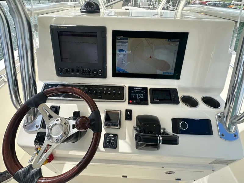 Slide: The Image of 2016 Cobia 296CC boat helm with navigation screens and controls. - 15