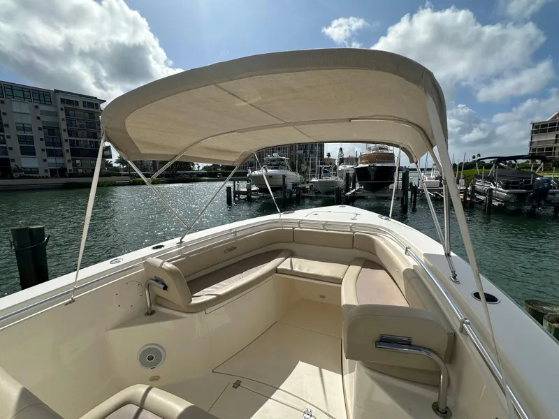 Slide: The Image of 2016 Cobia 296CC boat with canopy docked in a marina. - 26