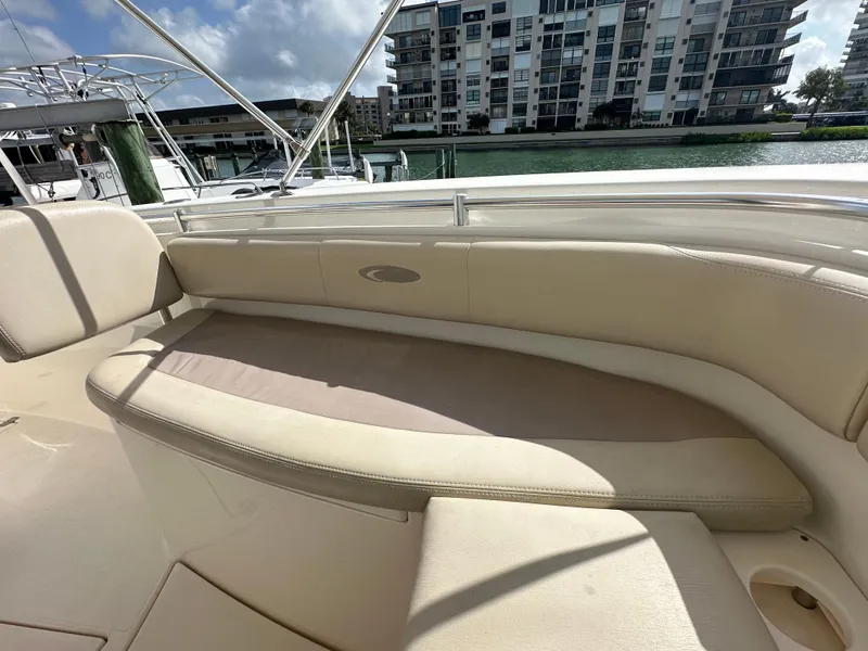 Slide: The Image of 2016 Cobia 296CC boat with beige seating and waterfront view. - 28