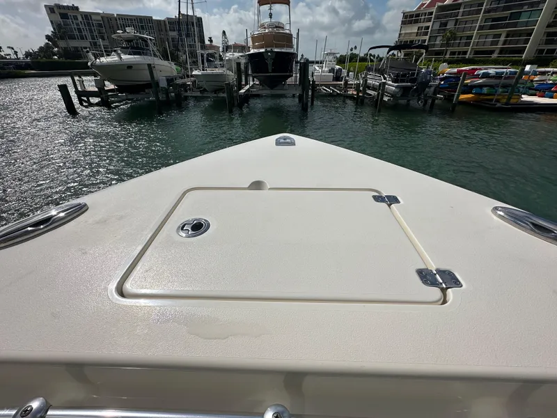 Slide: The Image of Bow view of a 2016 Cobia 296CC boat docked in a marina. - 29
