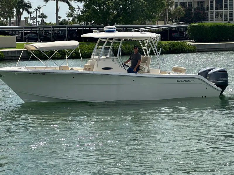 Slide: The Image of 2016 Cobia 296CC boat cruising on a sunny day in a calm waterway. - 3