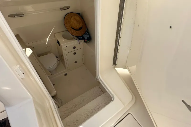 Slide: The Image of 2016 Cobia 296CC boat interior cabin with toilet and sink. - 32