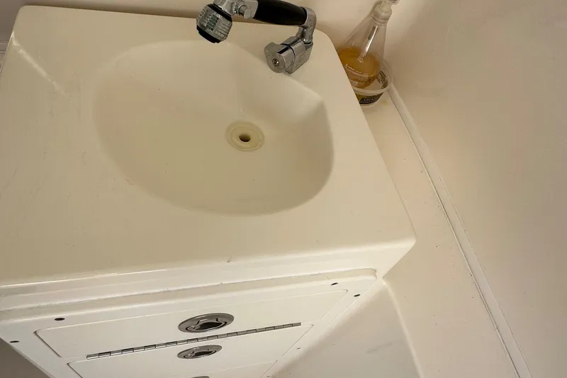 Slide: The Image of White sink and faucet in the 2016 Cobia 296CC boat bathroom. - 36