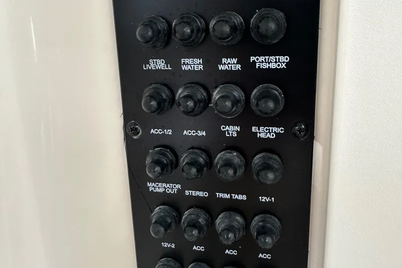 Slide: The Image of Control panel of a 2016 Cobia 296CC boat with labeled switches. - 37