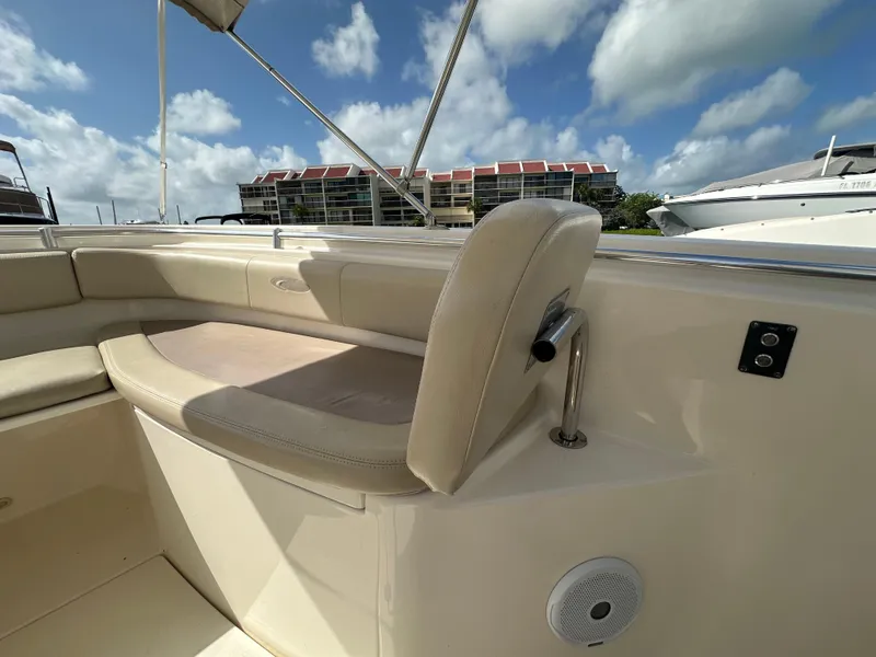 Slide: The Image of 2016 Cobia 296CC boat seating area with beige cushions and blue sky background. - 41