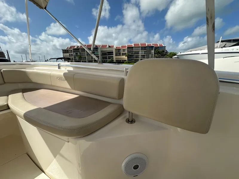 Slide: The Image of 2016 Cobia 296CC boat interior with beige seating and backrest under a blue sky. - 42
