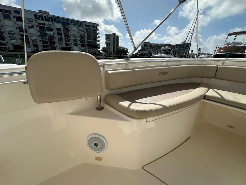 Slide: The Image of 2016 Cobia 296CC boat interior with cushioned seating and cityscape background. - 43
