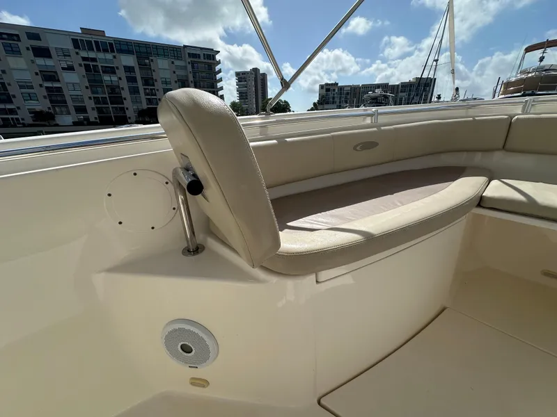 Slide: The Image of 2016 Cobia 296CC boat interior seating with cityscape background. - 44
