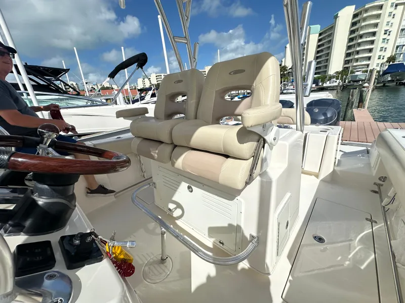 Slide: The Image of 2016 Cobia 296CC boat with dual captain's chairs at the helm, docked at a marina. - 47