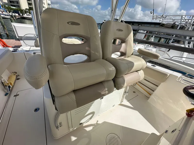 Slide: The Image of 2016 Cobia 296CC boat with dual beige captain's chairs on deck. - 49