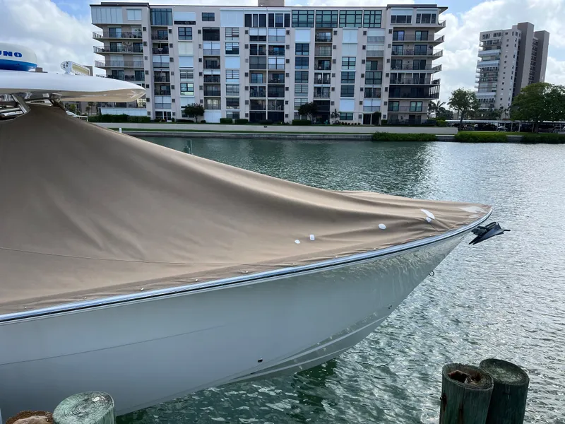Slide: The Image of 2016 Cobia 296CC boat with cover docked near waterfront apartments. - 5