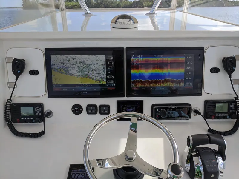 Slide: The Image of 2014 Invincible 42 Open Fisherman helm with dual navigation screens and controls. - 3