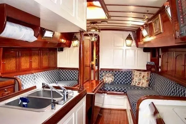 Slide: The Image of Interior of a 1983 Cherubini Schooner with wooden finishes and cozy seating area. - 17