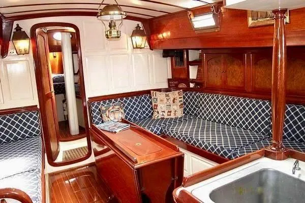 Slide: The Image of Interior of 1983 Cherubini Schooner with polished wood and blue patterned seating. - 18