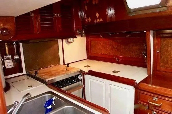 Slide: The Image of 1983 Cherubini Schooner kitchen with wooden cabinets and white countertops. - 19