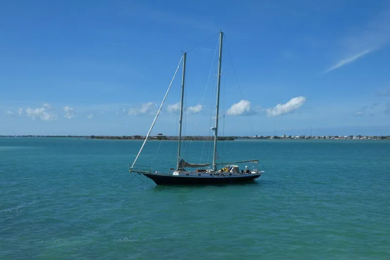 Slide: The Image of 1983 Cherubini Schooner sailing on calm blue waters under a clear sky. - 26