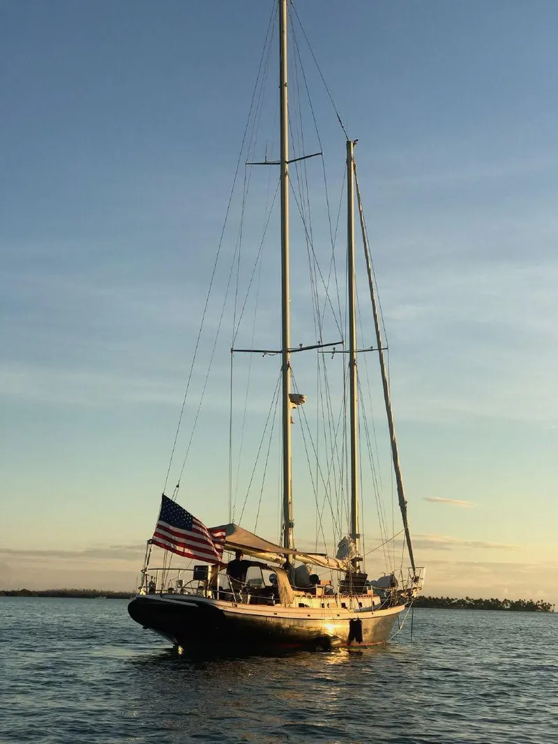 Slide: The Image of 1983 Cherubini Schooner sailing at sunset with American flag. - 27