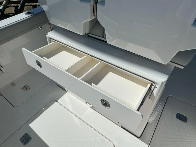 Slide: The Image of 2025 Pursuit S 248 boat interior with storage compartment and cup holders. - 13