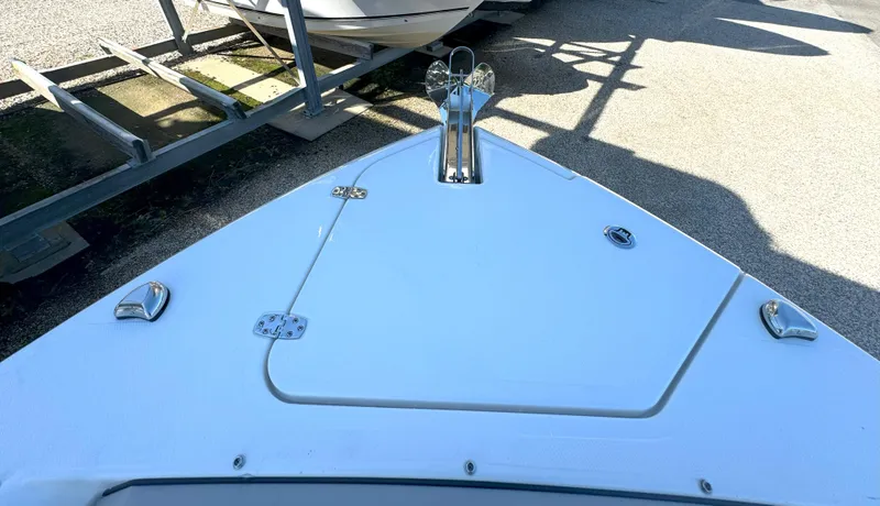 Slide: The Image of 2025 Pursuit S 248 boat anchor compartment in marina setting. - 25