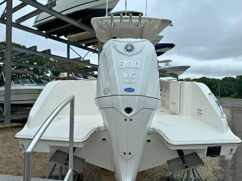 Slide: The Image of 2025 Pursuit S 248 boat with T-top and rod holders, parked outdoors. - 5