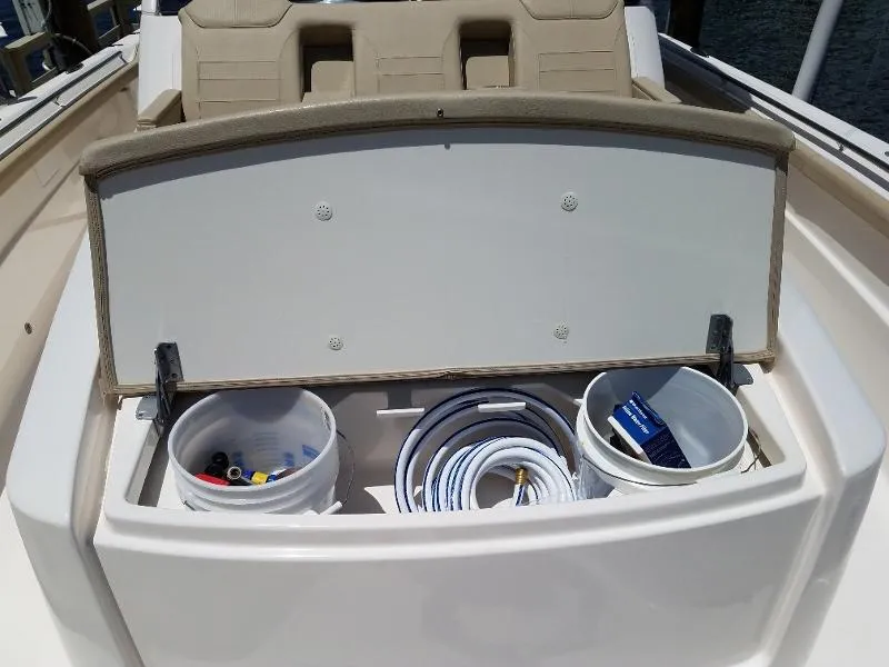 Slide: The Image of 2017 Pursuit S 408 Sport boat storage compartment with buckets and coiled hose. - 46