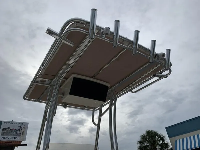Slide: The Image of Pioneer Islander 180 boat canopy, 2025 model, with rod holders against cloudy sky. - 12