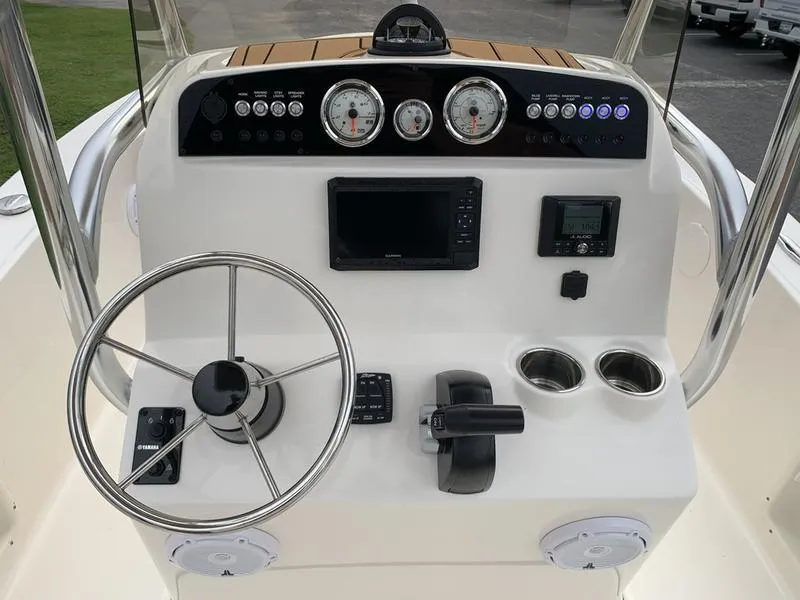 Slide: The Image of 2025 Pioneer Islander 180 boat dashboard with steering wheel, gauges, and controls. - 14