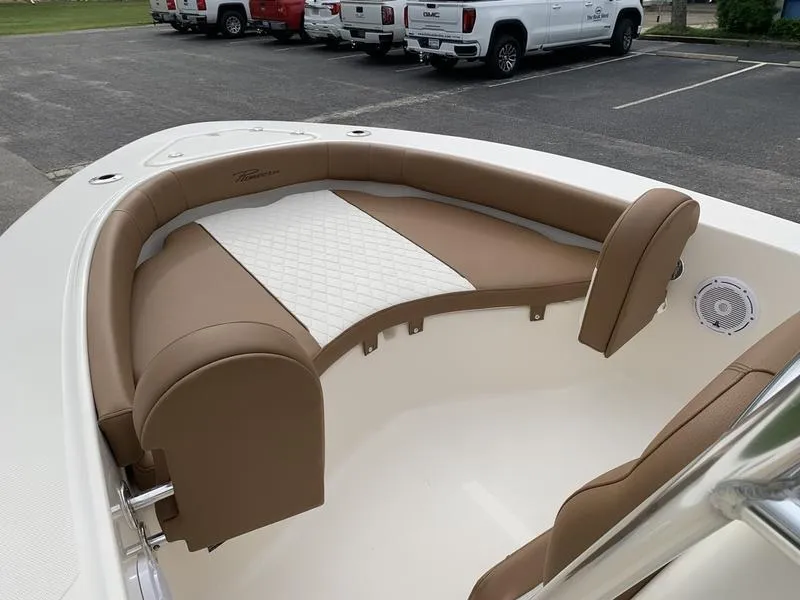 Slide: The Image of 2025 Pioneer Islander 180 boat with tan and white seating in a parking lot. - 21