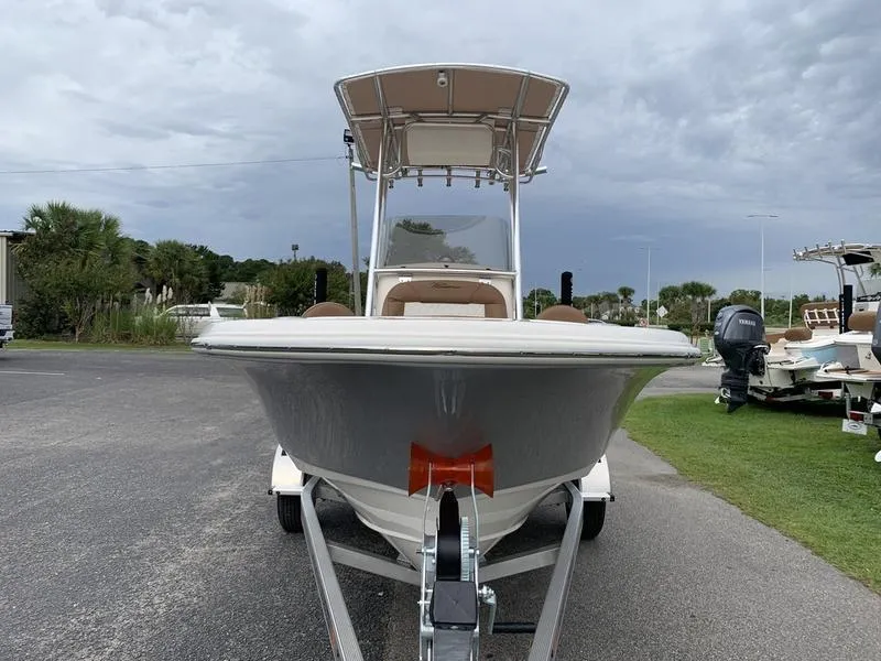 Slide: The Image of 2025 Pioneer Islander 180 boat on trailer, parked outdoors under cloudy sky. - 7
