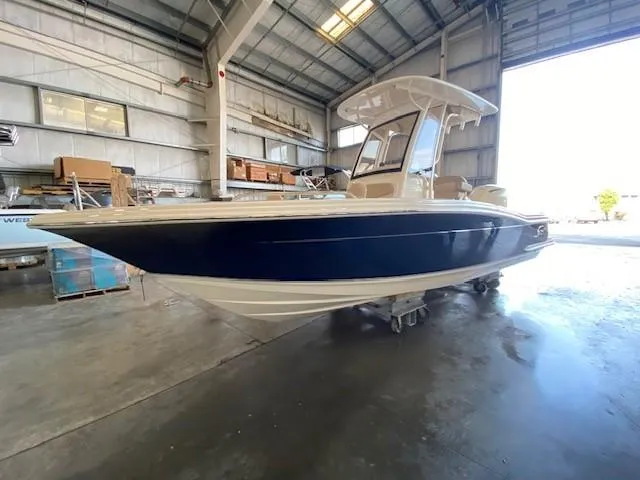 Slide: The Image of 2025 Scout 215 XSF boat in a warehouse, side view. - 2