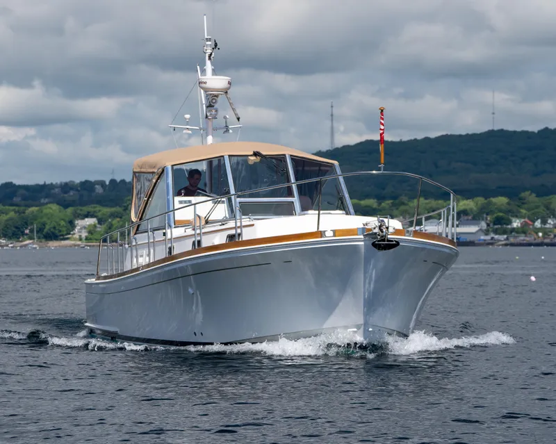 Slide: The Image of Grand Banks Eastbay 43 Ex 2000 cruising near a coastal lighthouse. - 7