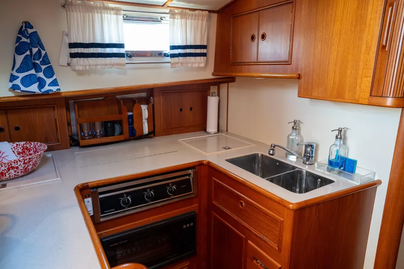 Slide: The Image of 2000 Grand Banks Eastbay 43 Ex galley with wood cabinetry, sink, and stove. - 49