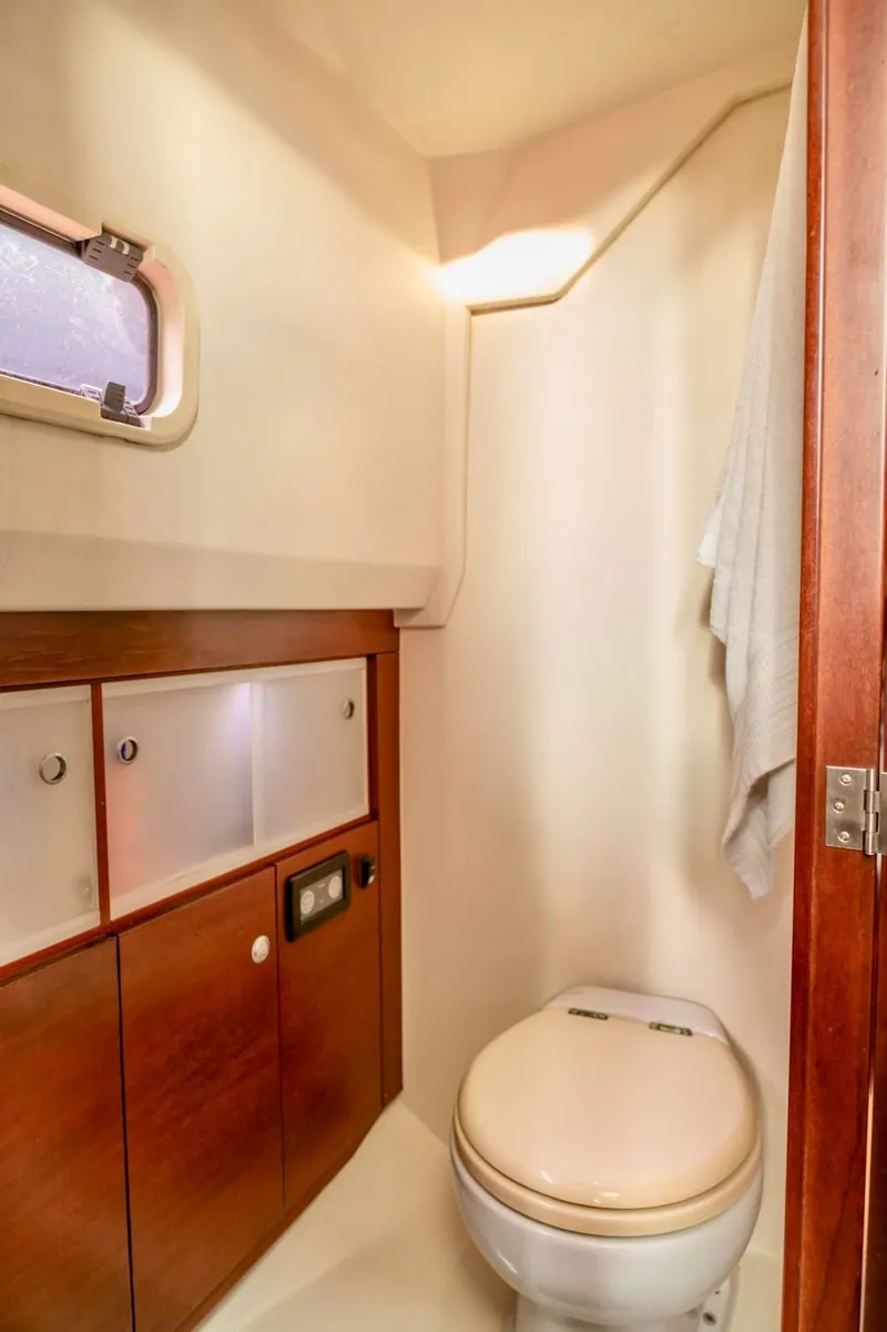 Slide: The Image of 2008 Fjord Express boat bathroom with wooden cabinets and compact toilet. - 15