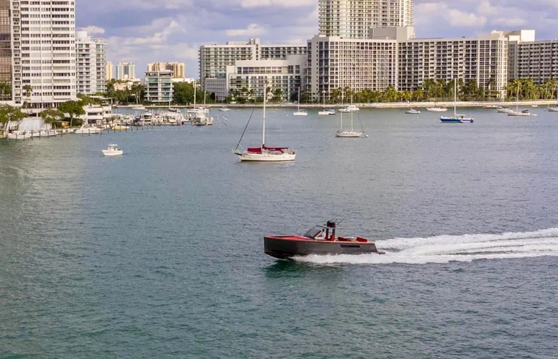 Slide: The Image of Speedboat cruising in a city harbor, surrounded by sailboats and skyscrapers, Fjord Express 2008. - 30