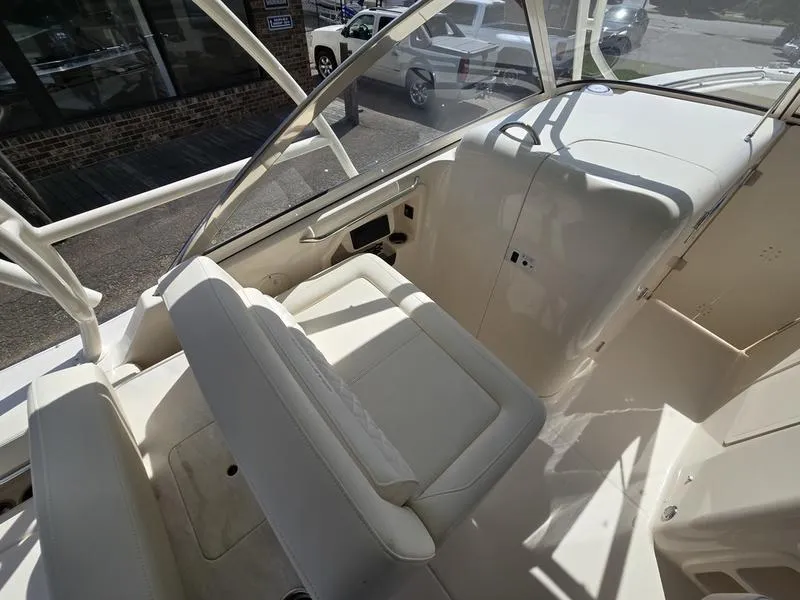 Slide: The Image of 2024 Grady-White Freedom 307 boat interior with white seating and helm station. - 10