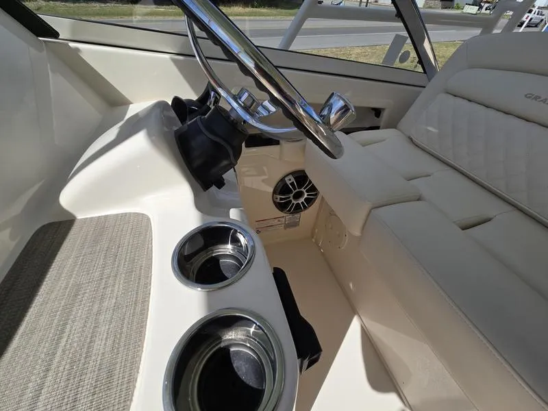 Slide: The Image of 2024 Grady-White Freedom 307 boat interior with steering wheel and cup holders. - 18