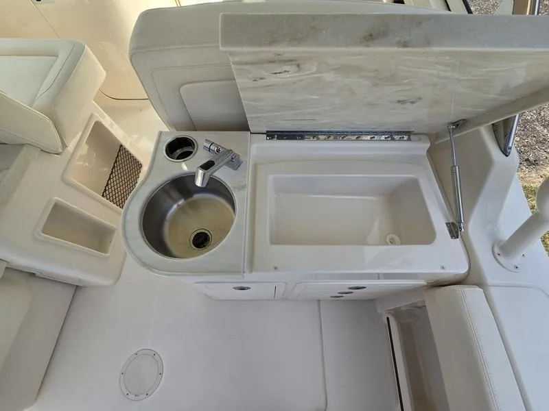Slide: The Image of 2024 Grady-White Freedom 307 boat interior with sink and storage compartments. - 19