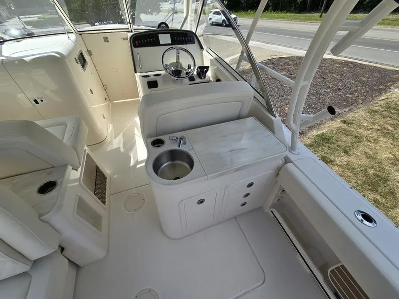 Slide: The Image of 2024 Grady-White Freedom 307 boat interior with helm, seating, and sink. - 8