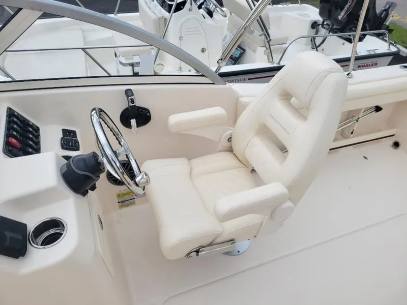 Slide: The Image of 2025 Grady-White Freedom 215 boat interior with steering wheel and captain's chair. - 15