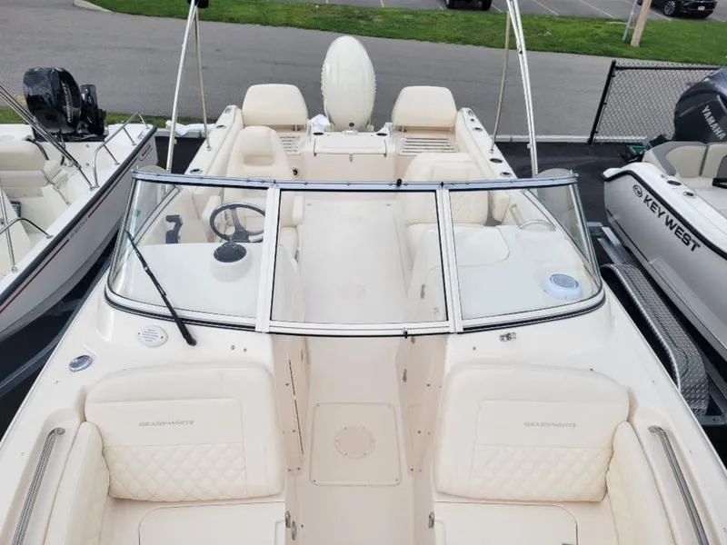 Slide: The Image of 2025 Grady-White Freedom 215 boat, spacious seating, sleek design, parked at marina. - 18