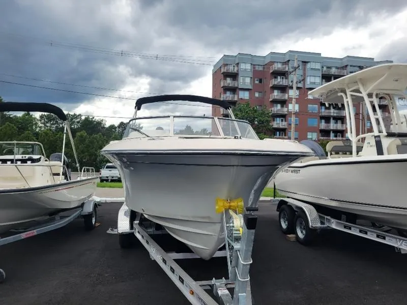 Slide: The Image of 2025 Grady-White Freedom 215 boat on trailer, parked outdoors under cloudy sky. - 2